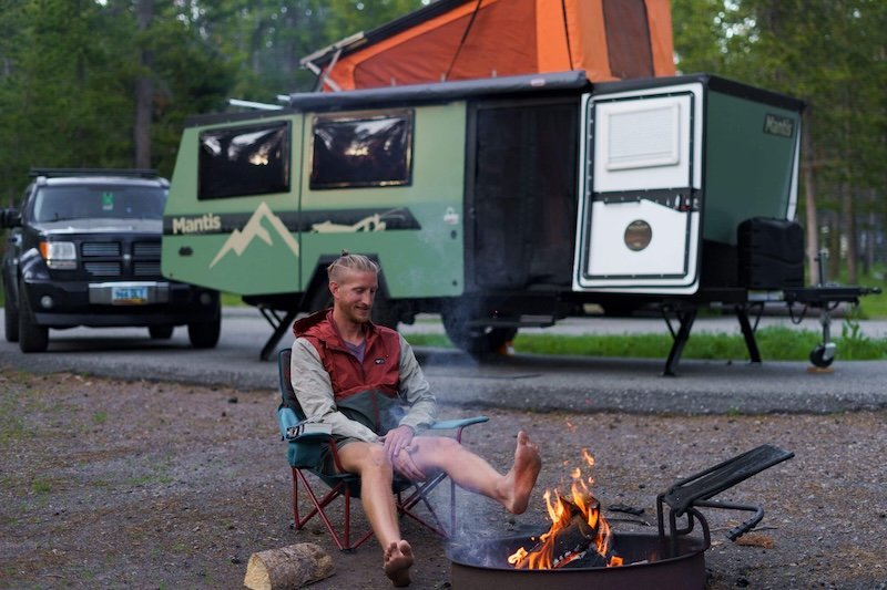 Sheridan enjoying a fire with taxa outdoors camper in Yellowstone national park